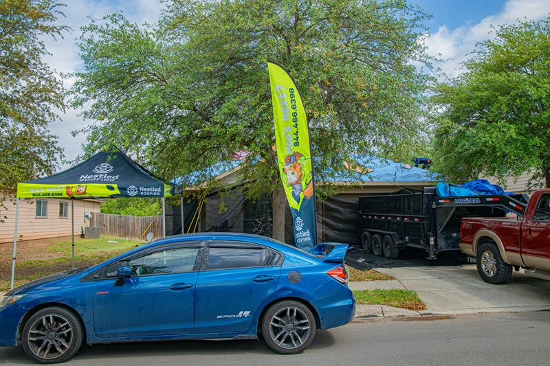 Nestled Roofing truck and equipment set up at a job site